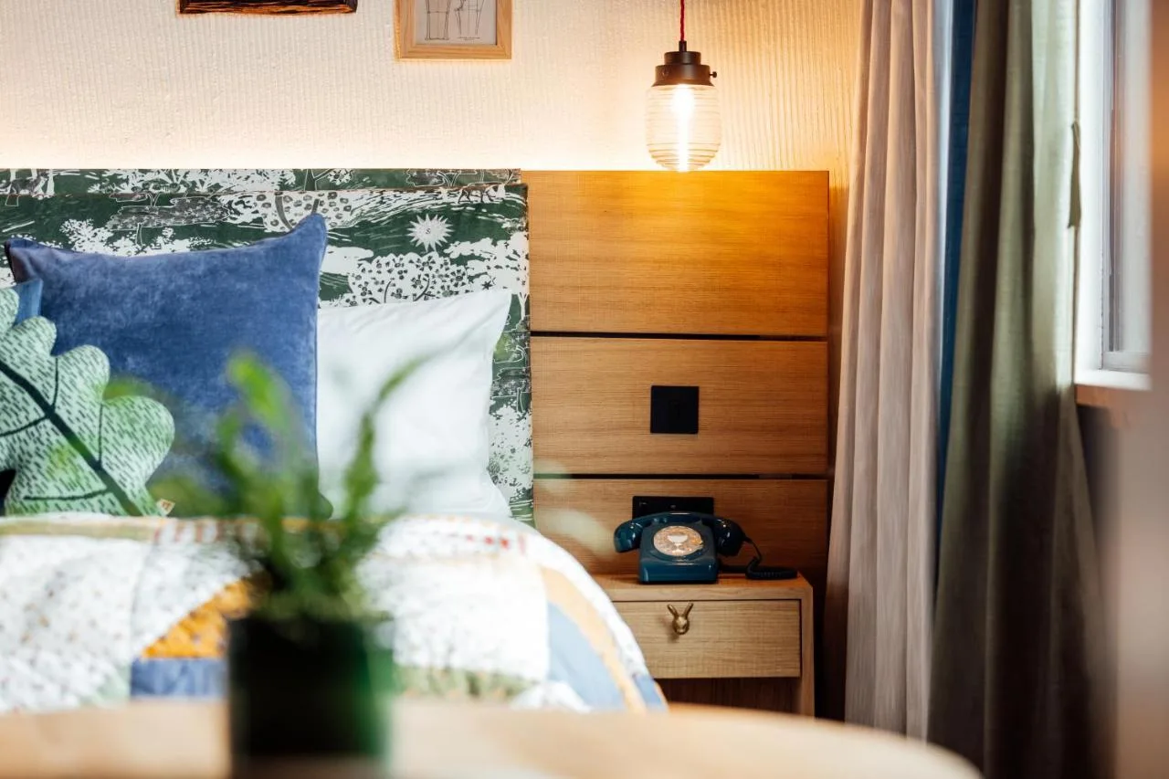 Bedroom with bed and bedside clock at Treehouse Hotel Manchester